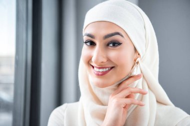 Kameraya gülümseyen güzel mutlu genç Müslüman bir kadın portresi 