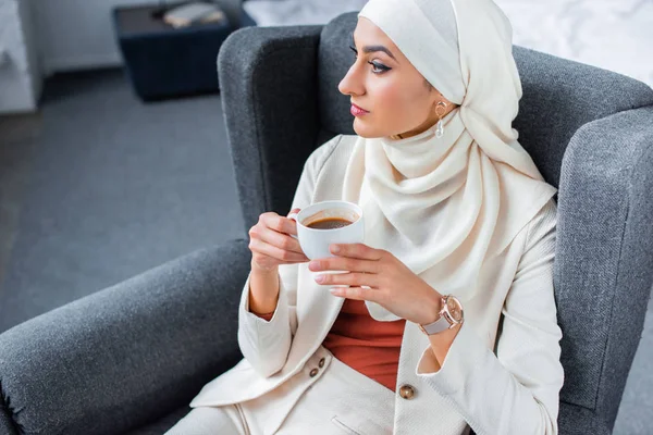 Joven Mujer Musulmana Sosteniendo Una Taza Café Mirando Casa — Foto de Stock