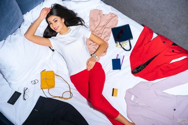 Beautiful Girl Smiling Camera While Lying Bed Fashionable Clothes Handbags — Stock Photo, Image