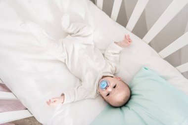 Küçük Bebek beşiğinde yatan emzik ile havai görünümü