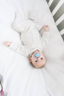 Küçük Bebek beşiğinde yatan emzik ile havai görünümü