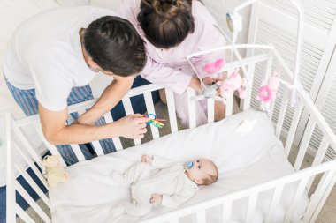 Genç Anne bebek beşik evde bakarak yüksek açılı görünüş