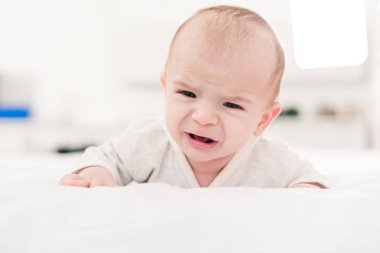 yatakta yatarken ağlıyor küçük bebek çocuk portresi