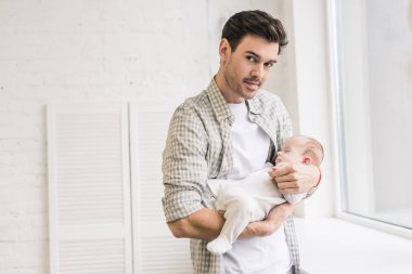 Genç adam holding uyuyan bebek elinde portresi