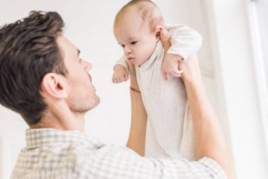 Genç baba ve küçük bebek evde yan görünüm