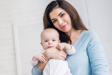 Genç Anne ile evde elinde küçük bebek portresi
