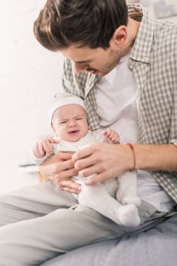 Babası holding ağlayan bebeğin elinde portresi