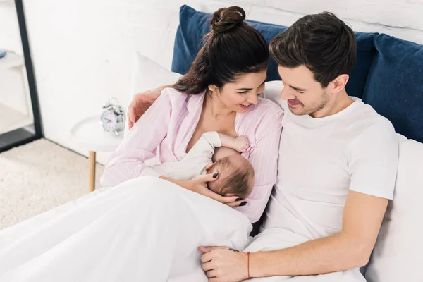 Retrato Madre Sonriente Amamantando Bebé Con Marido Cerca Cama Casa —  Fotos de Stock