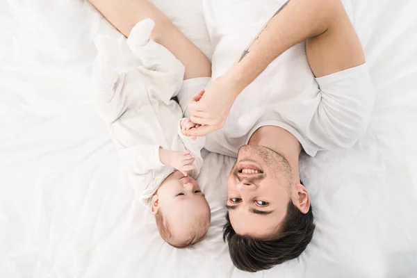 Vista Aérea Padre Sonriente Pequeño Bebé Acostados Cama Juntos Casa —  Fotos de Stock