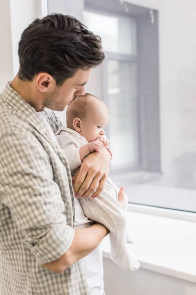 若い父親と自宅の小さな赤ちゃんの側面図 — ストック写真