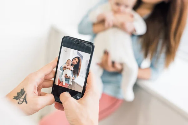 Oříznutý Snímek Člověka Vyfotit Ženu Dítětem Ruce Smartphone — Stock fotografie