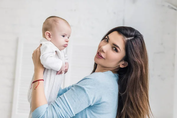 Fiatal Anya Látszó Fényképezőgép Míg Gazdaság Baba Kezében Oldalnézete — Stock Fotó