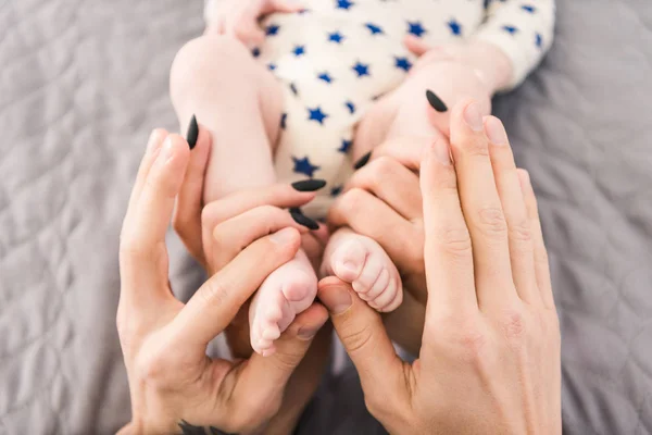 Visão Parcial Dos Pais Segurando Pequenos Bebês Pés Nas Mãos — Fotografia de Stock