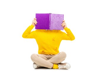 oturan ve üzerinde beyaz izole kitap arkasında yüz gizleme kız öğrenci