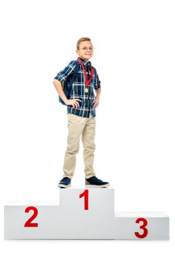 happy boy standing on winner podium, smiling and looking at camera isolated on white clipart
