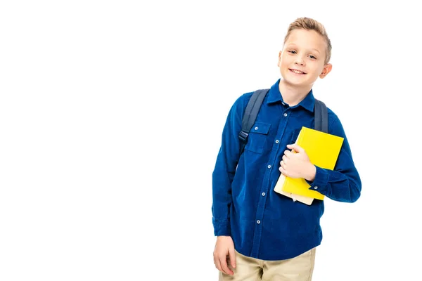 白で隔離カメラを見ながら本を保持しているバックパックと青いシャツを着て男子生徒 — ストック写真
