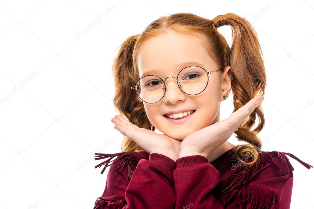 adorable child in glasses smiling and looking at camera isolated on white