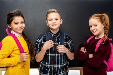 kamera önünde blackboard bakarak sırt çantaları ile okul gülümseyen 