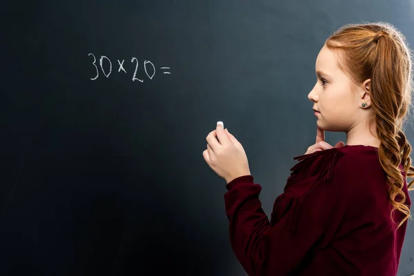 Вдумчивая Школьница Держит Мел Смотрит Доску Математическим Примером — стоковое фото