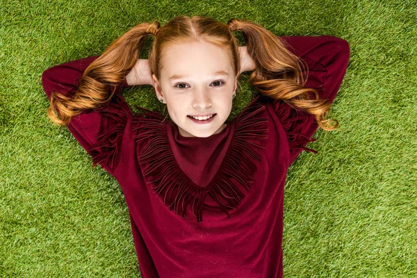 Top View Smiling Schoolgirl Hands Head Looking Camera Lying Lawn — Stock Photo, Image