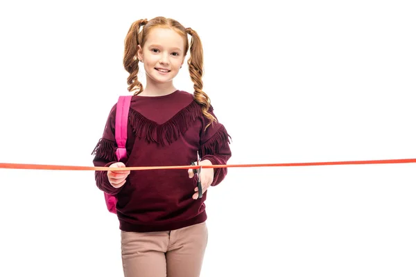 Smiling Schoolgirl Cutting Red Ribbon Looking Camera Isolated White — Stock Photo, Image