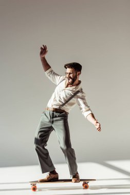 yakışıklı longboard gri arka plan üzerinde kişini sakallı