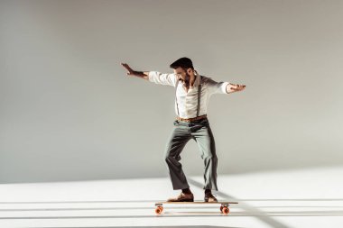 longboard gri arka plan üzerinde sürme forma kollu yakışıklı sakallı adam