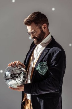 disko topu gri arka plan üzerinde tutarak gözlük yakışıklı sakallı adam
