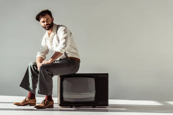 Schöner Bärtiger Mann Sitzt Auf Vintage Fernseher Und Schaut Die — Stockfoto