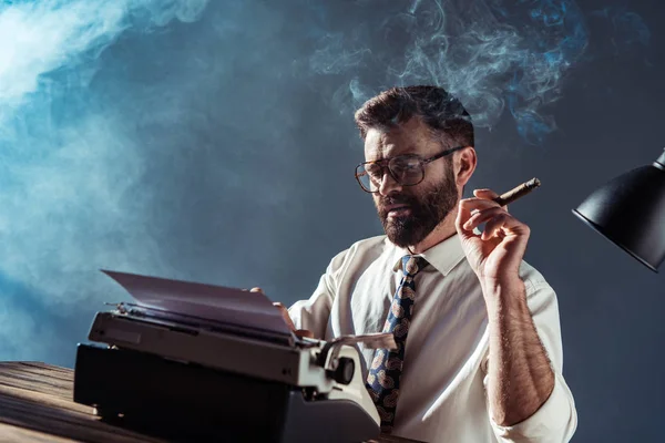 Jornalista Barbudo Sentado Mesa Com Máquina Escrever Retro Fumando Fundo — Fotografia de Stock