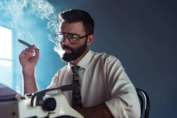 Thoughtful Handsome Journalist Glasses Sitting Table Retro Typewriter Smoking Window — Stock Photo, Image