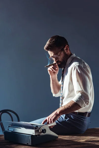 英俊的男人吸烟和使用打字机 — 图库照片