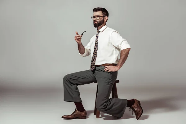 Handsome Bearded Man Glasses Sitting Chair Holding Pipe — Stock Photo, Image