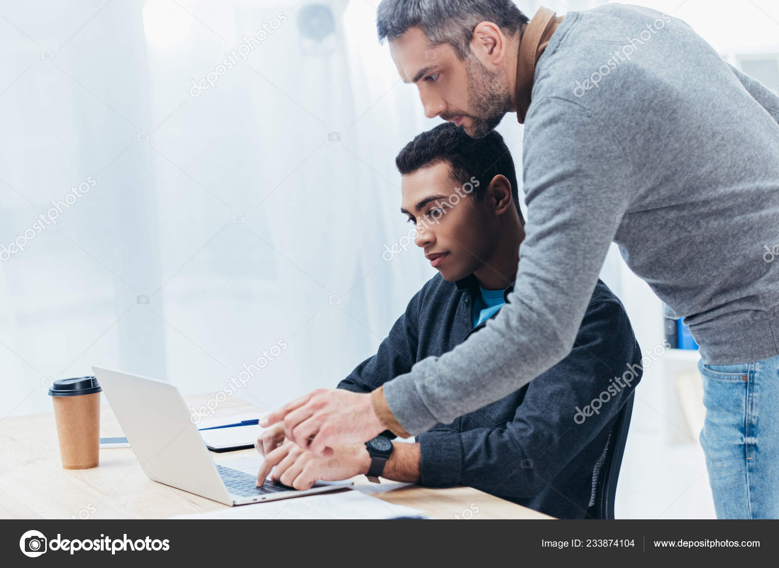 Bearded Mentor Helping Young Colleague Laptop Stock Photo by ©AllaSerebrina 233874104