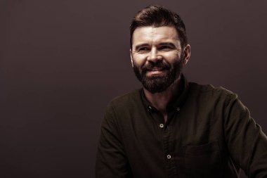 kahverengi üzerine izole kahverengi gömlek gülümseyen yakışıklı sakallı adam