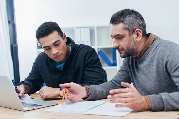 Compañeros Trabajo Masculinos Concentrados Que Trabajan Con Papeles Portátiles Oficina — Foto de Stock