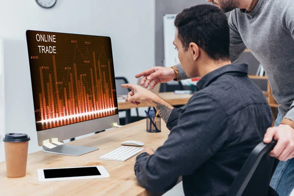 オフィスで画面上のオンライン貿易グラフをデスクトップ コンピューターを使用してビジネス同僚のショットをトリミング — ストック写真