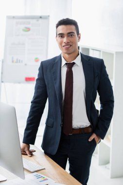 elle cebinde duran ve kamera Office gülümseyen yakışıklı genç işadamı