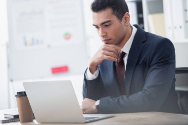 dizüstü bilgisayar Office ile çalışan takım elbiseli genç işadamı odaklı