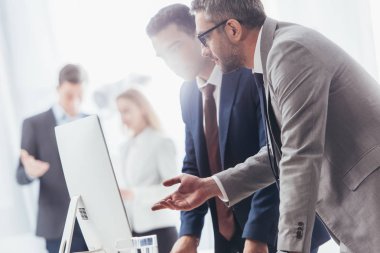Masaüstü bilgisayar kullanma ve iş ofis tartışırken resmi olarak profesyonel iş adamları giymek 