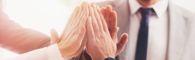 close-up partial view of professional  business team giving high five in office