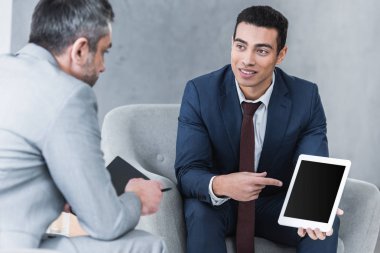 Dijital tablet boş ekran ile işaret ve konuşma sırasında erkek meslektaşı arıyorum genç işadamı gülümseyen