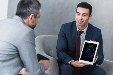 Dijital tablet meslektaşım için gösterilen gülümseyen genç işadamı   