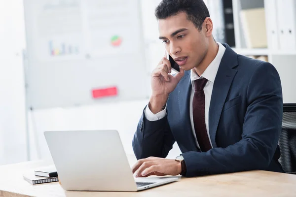 Concentrated Young Businessman Talking Smartphone Using Laptop Workplace — Stock Photo, Image