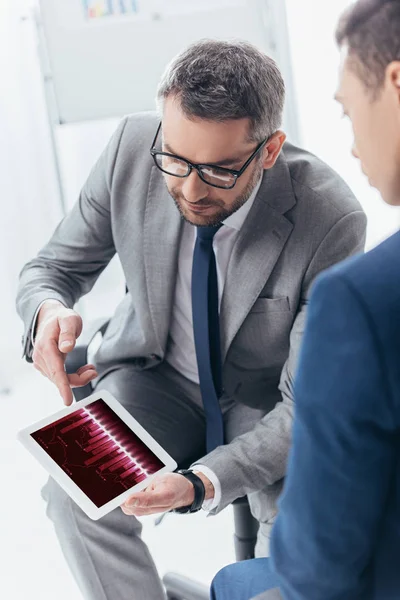 Erkek meslektaşı Office dijital tablet ticaret grafikler ile gösterilen gözlük işadamı kadeh kırpılmış
