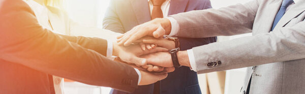 обрезанный снимок профессиональных успешных бизнесменов, складывающих руки вместе
  