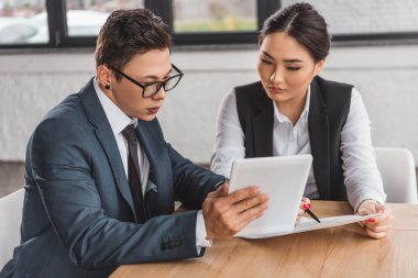 ciddi genç kazak iş adamları dijital tablet ve Office belgeleri ile çalışma 
