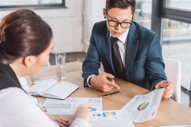 grafikler ve Office ile çalışan genç Asya iş adamları
