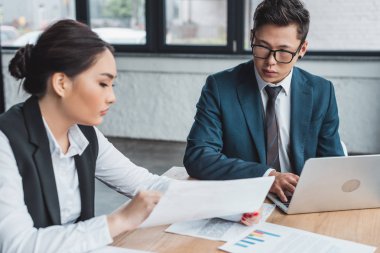çalışma kağıtları ve office içinde laptop ile genç kazak iş adamları