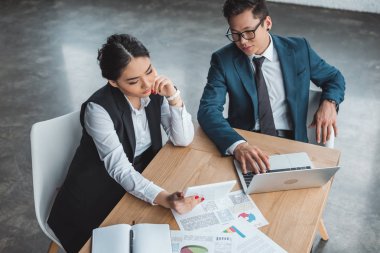 dijital cihazlar ve Office belgeleri ile çalışan genç Asya iş adamları yüksek açılı görünüş 